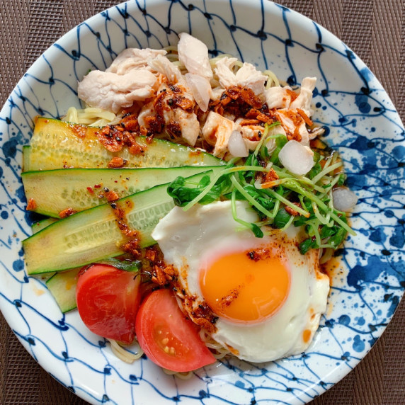 Chinese noodles are boiled and cooled, and various ingredients are arranged radially on top. 