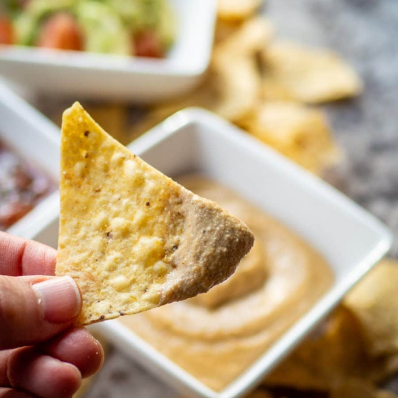 Vegan queso on a tortilla chip.