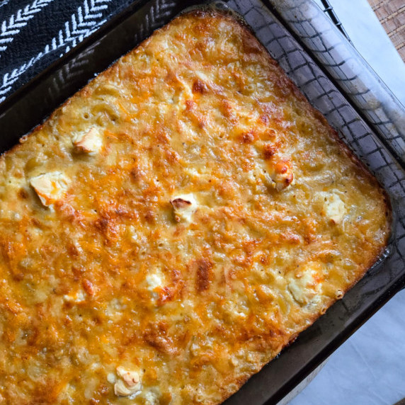 Golden brown, baked macaroni pie in a glass baking dish.