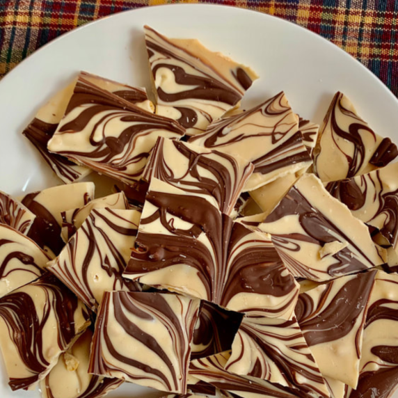 Tiger Butter Bark on white plate on a plaid tablecloth.