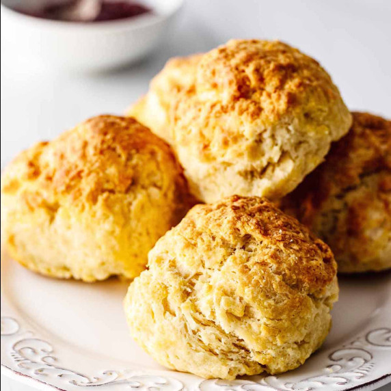 Four air fryer biscuits stacked on a white plate.