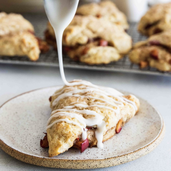 Apple scone served on a plate with a glaze.