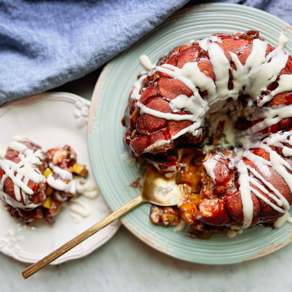 Top down view of apple monkey bread on a plate with a piece of it on another plate.