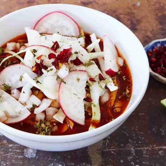 Red Pork Pozole soup in white bowl