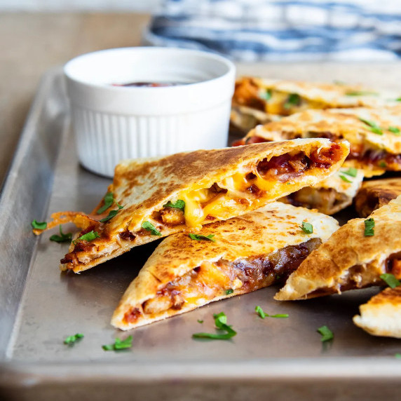 Image of sliced bbq chicken quesadillas on a metal pan.