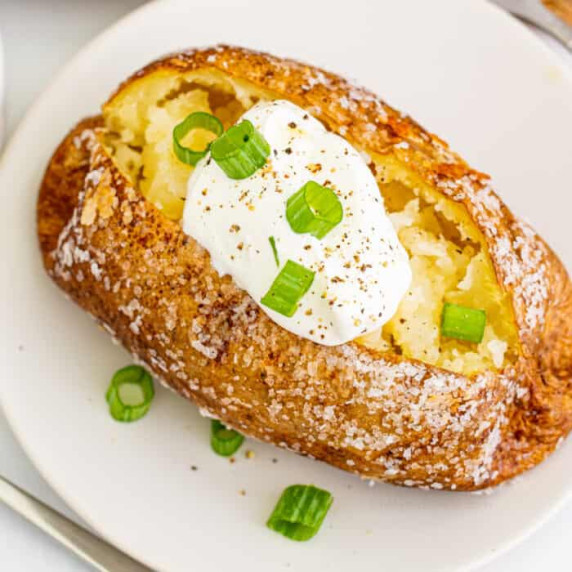 Close up overhead of a baked potato with sour cream.