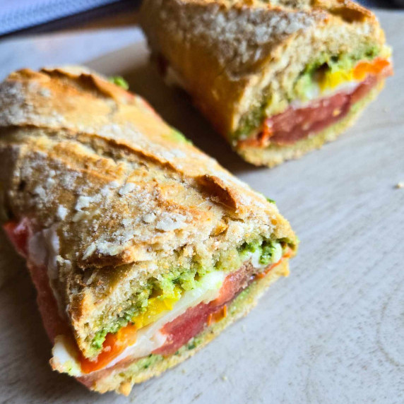 Toasty golden baguettes stuffed with green pesto, white cheese, and red tomatoes.