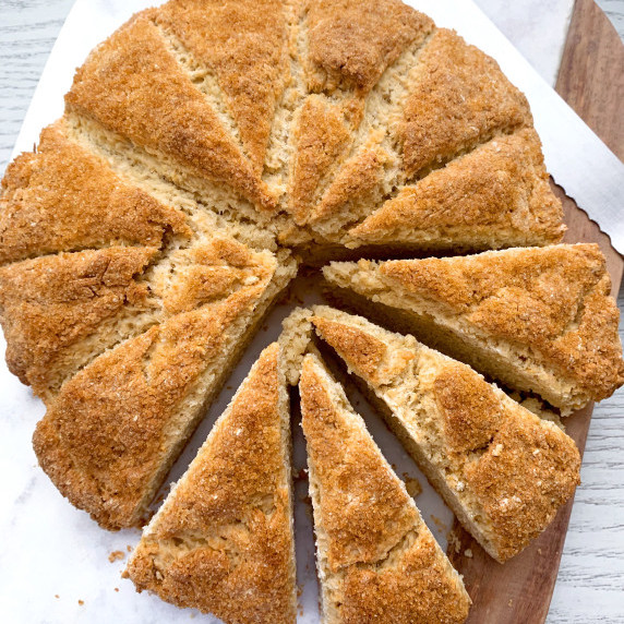banana scones with some sliced on a marble and wood cutting board