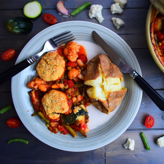 Bean and vegetable hotpot served with cheese dumplings and a jacket potato