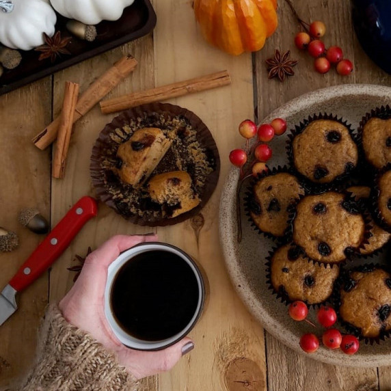 Overhead image of chocolate spoted pumpkin muffins on Autumn wooden table.