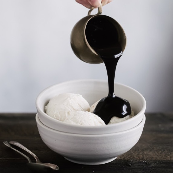 chocolate sauce being poured on ice cream