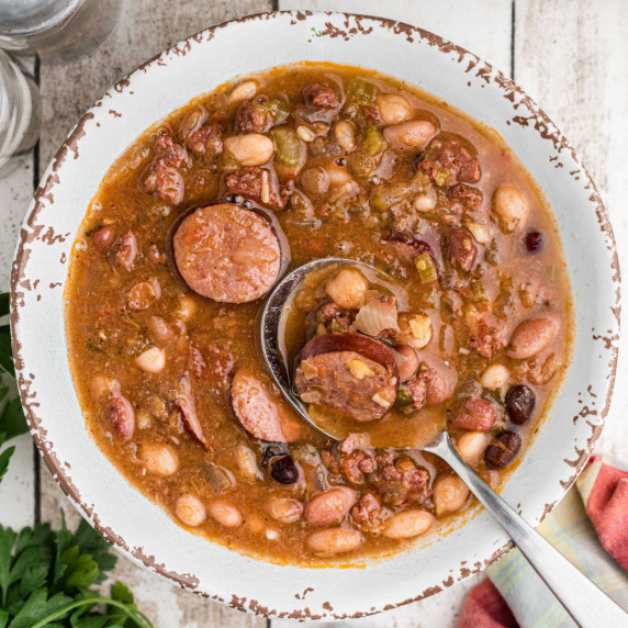 A bowl of Cajun 15 Bean Soup with a spoon digging into it.