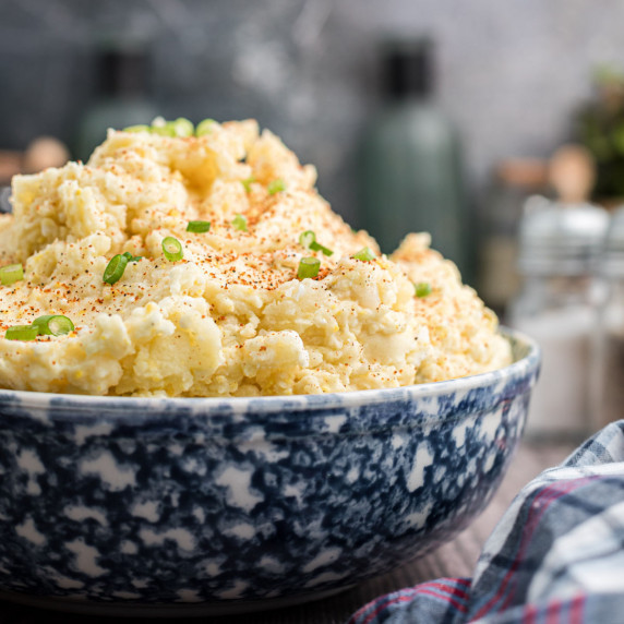 close up of a large blue bowl of potato salad