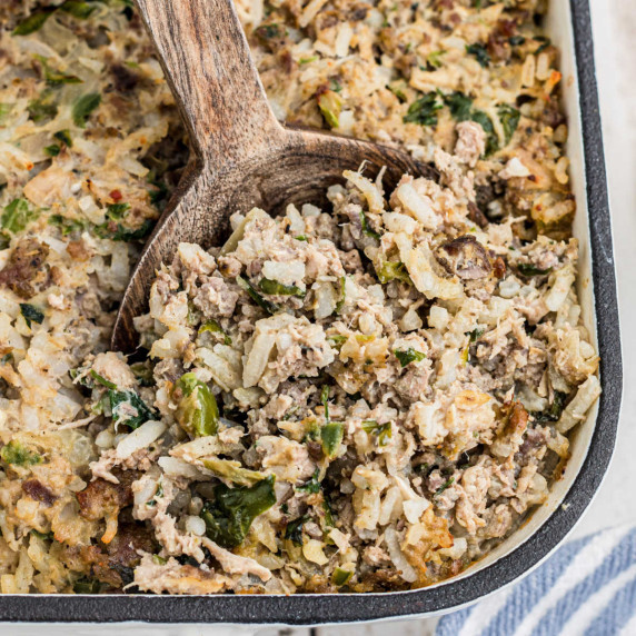 close up shot of the corner of a casserole dish filled with cajun rice dressing.