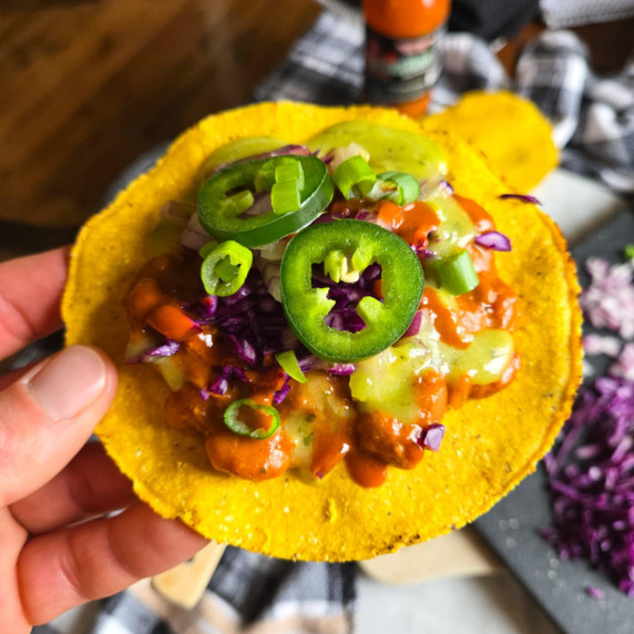 Golden tostada topped with an assortment of colourful toppings.
