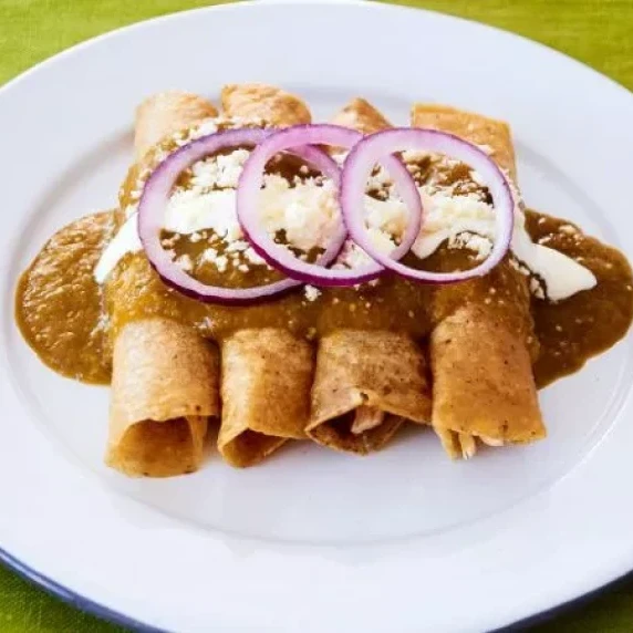 Chicken Enchiladas with Homemade Salsa Verde top with onion served on a plate