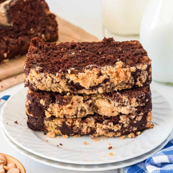 Stack of chocolate peanut butter loaf sliced and stacked on a plate from the side.