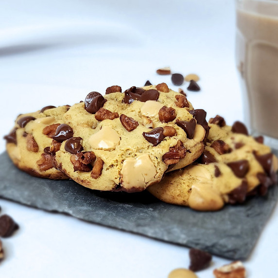 Turtle style chocolate chip cookies for two on a slate board with a glass of chocolate milk