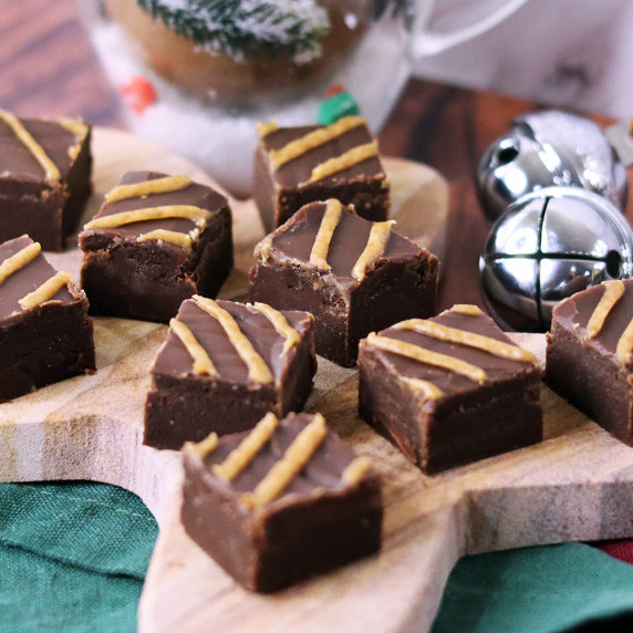 Old Fashioned Chocolate Peanut Butter Fudge arranged on a holiday plate against a white background.