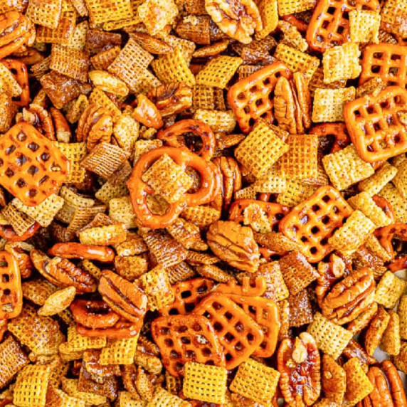 Close up of Chex Mix showing pretzels, Chex cereal, and pecans coated in cinnamon and sugar.