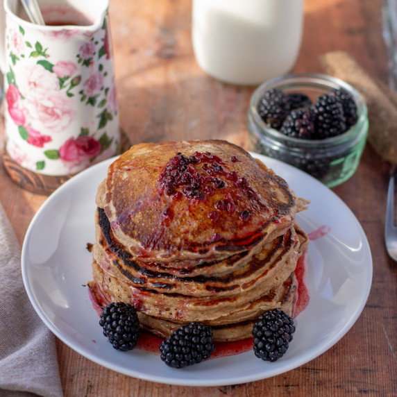stack of cinnamon whole wheat pancakes with blackberry brown butter syrup