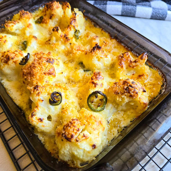 A baking dish full of golden brown, creamy baked cauliflower.