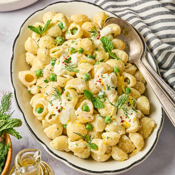 Creamy garlic lemon pasta with green peas, fresh herbs, and a whipped cottage cheese sauce, served i