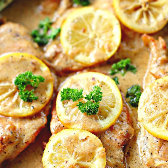 Chicken breast smothered in creamy rich sauce, topped with lemons and parsley