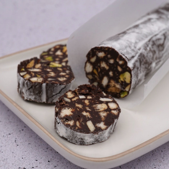 A partly sliced chocolate salami