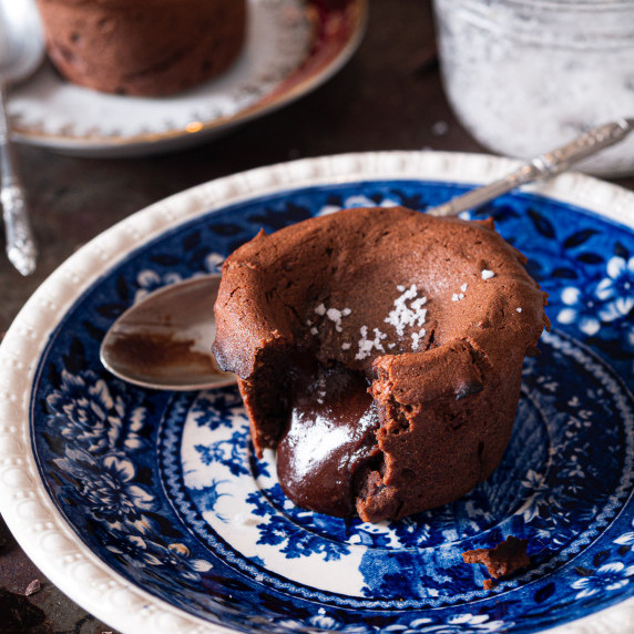 chocolate lava cake in a blue plate with its chocolate heart melting