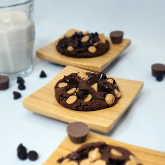 Double Chocolate Chip Cookies on small wooden plates with a glass of milk