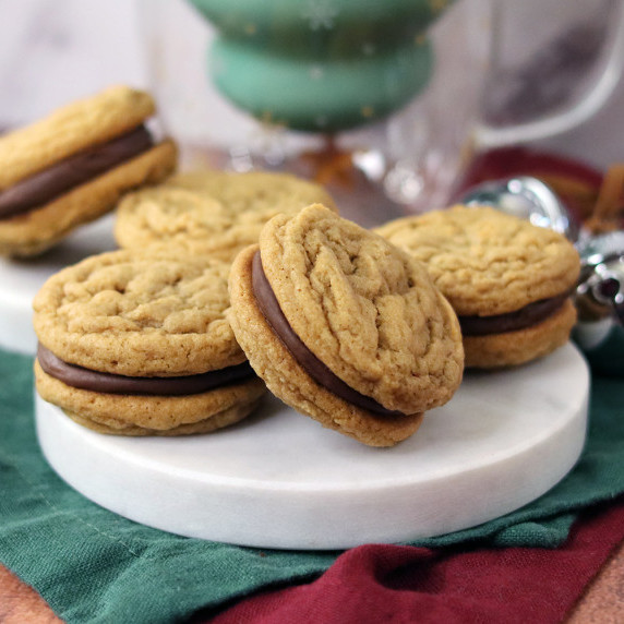 Dulce de Leche Duo cookies on a holiday plate with a holiday mug in the background