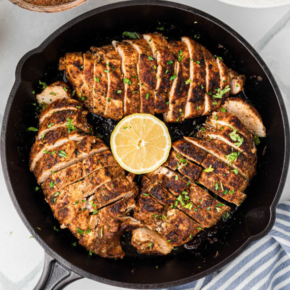 Overhead shot of a skillet with blackened chicken breasts.