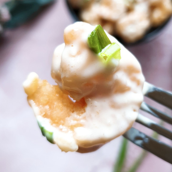 Creamy Coconut Shrimp being held by a fork.