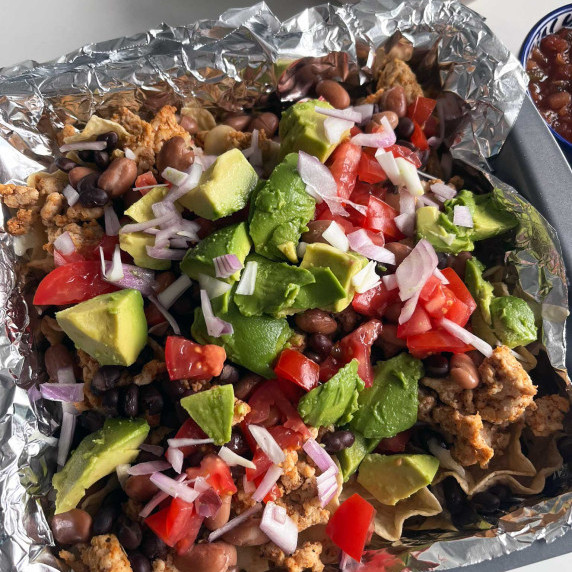 fully loaded nachos in a baking pan