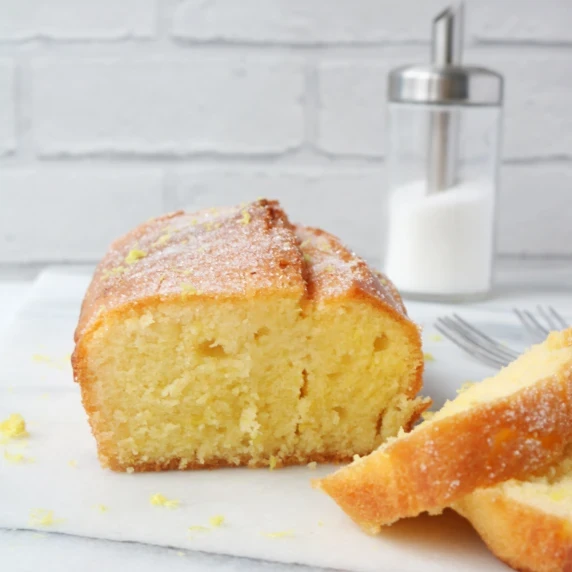 sliced cake sitting on a white background in front of a white brick wall 
