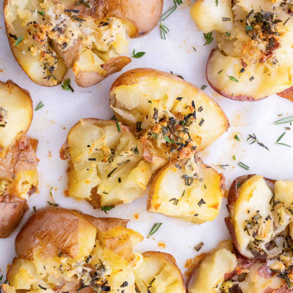 Smashed Red Potatoes Recipe garnished on a sheet pan.