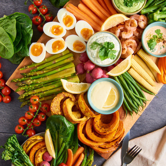 A board filled with Grand Aioli. 4 Aioli versions, a variety of vegetables, prawns, eggs and potato