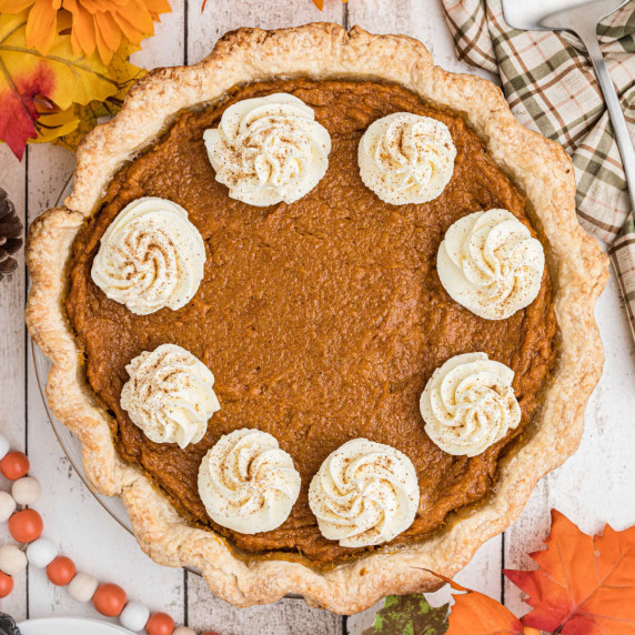 Overhead view of an old fashioned sweet potato pie with swirls of cream.