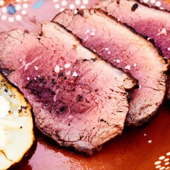 Grilled Sirloin Cap Roast with simple charcoal-grilled baked potato on the side.