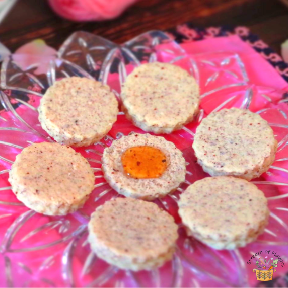 Ground hazelnut cookies with orange blossom honey on a glass plate with a pink napkin