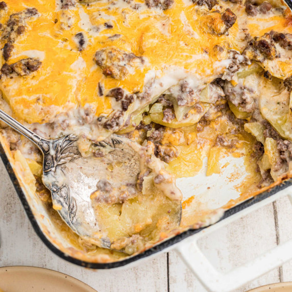 Close up of the corner of a hamburger potato casserole with a spoon left in.