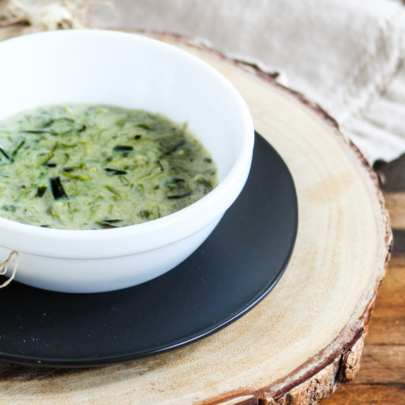 green sauce in white bowl with tan napkin underneath