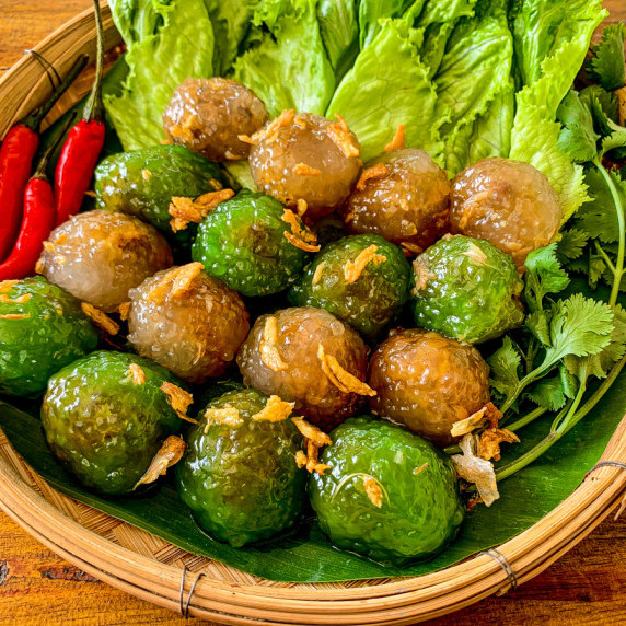 Thai tapioca dumplings with pork filling and a side of lettuce and chilies.