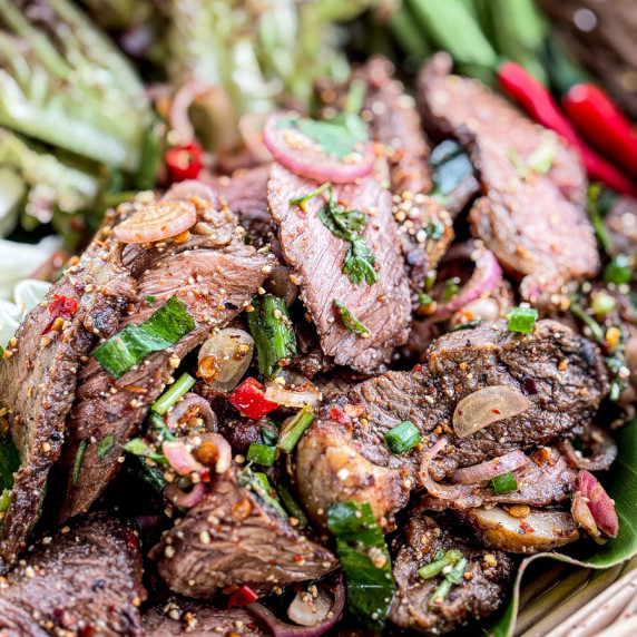 Close-up of Thai nam tok beef salad with visible herbs and spices.