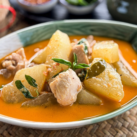Close-up of Thai winter melon curry with chicken in red curry sauce.