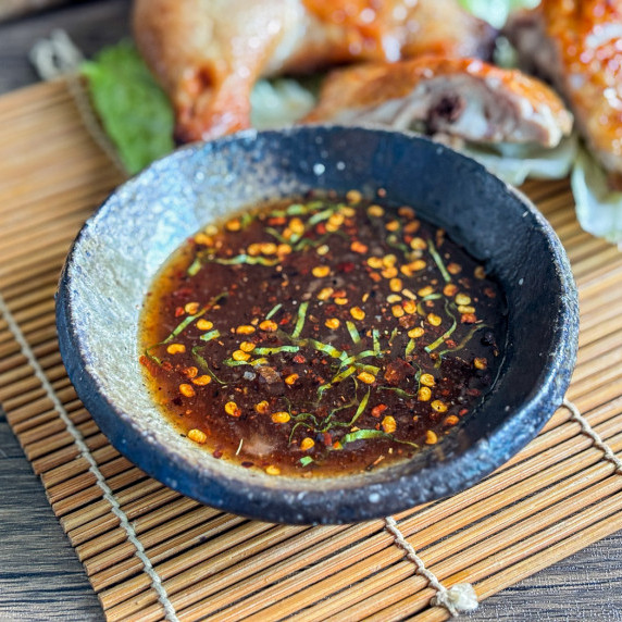Close-up of grilled chicken sauce on a bamboo placemat.