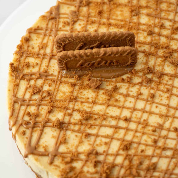 Partial view of Biscoff cookie butter cheesecake topped with cookie butter drizzle 