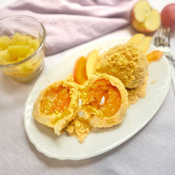 apricot dumplings on s white dish, apples and a cup with apple compote