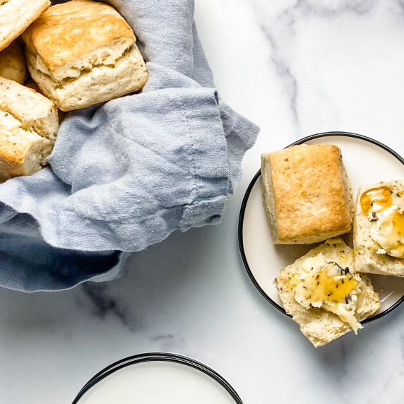 Parmesan and Black truffle biscuits with herbed honey butter on a plate